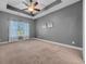 Spacious bedroom features a tray ceiling, neutral walls and carpet, with a window view at 605 Fieldwoods Dr., Conway, SC 29526