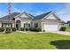 Traditional single-story home featuring a lush green lawn and a two-car garage at 605 Fieldwoods Dr., Conway, SC 29526