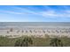 Relaxing view of a picturesque beach with crystal clear water and chairs with umbrellas at 6900 N Ocean Blvd. # 421, Myrtle Beach, SC 29572
