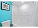 Modern bathroom with white tiled shower and turquoise accent wall at 7200 N Ocean Blvd. # 224, Myrtle Beach, SC 29572