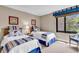 Cozy bedroom featuring two twin beds with nautical-themed bedding and a sunlit window at 741 Retreat Beach Circle # B-1-A, Pawleys Island, SC 29585