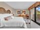 Comfortable bedroom features a wicker headboard, balcony access, and bright natural light at 741 Retreat Beach Circle # B-1-A, Pawleys Island, SC 29585