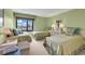 Bright bedroom featuring three twin beds, soft green decor, and a large window with outdoor views at 741 Retreat Beach Circle # B-1-A, Pawleys Island, SC 29585