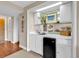 Charming wet bar featuring white cabinetry, mini-fridge, sink, and decorative nautical accents at 741 Retreat Beach Circle # B-1-A, Pawleys Island, SC 29585