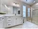 Bright bathroom features double sinks, white cabinetry and a glass door shower with tile surround at 748 Old Murrells Inlet Rd., Murrells Inlet, SC 29576