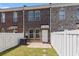 Brick townhouse featuring an enclosed backyard with grass, patio, and white fencing at 750 Howard Ave. # E, Myrtle Beach, SC 29577