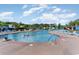 Spacious community pool with ample seating, umbrellas, and lush landscaping under a bright sky at 750 Howard Ave. # E, Myrtle Beach, SC 29577