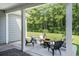 Covered patio with seating area and view of the wooded backyard at 775 Harrison Mill St., Myrtle Beach, SC 29579