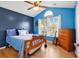 Comfortable bedroom with blue accent wall, vaulted ceiling, and large window at 824 Dunoway Ct., Myrtle Beach, SC 29579