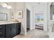 Modern bathroom featuring a dark vanity with a white countertop, a palm tree art, and access to the Primary bedroom at 866 Fowler Rd., Conway, SC 29526