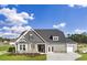 Charming two-story home featuring gray siding, stone accents, and a well-manicured front lawn under a bright blue sky at 866 Fowler Rd., Conway, SC 29526