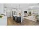Open-concept kitchen and living room boasts white cabinets, stainless steel appliances, and a large island with seating at 866 Fowler Rd., Conway, SC 29526