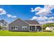 Gray home featuring a cozy screened-in porch, nestled in a beautifully maintained yard and lush green landscape at 866 Fowler Rd., Conway, SC 29526