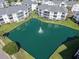 Aerial view of pristine condominiums surrounding a tranquil pond with fountain, showcasing community's serene setting at 901 West Port Dr. # 305, North Myrtle Beach, SC 29582