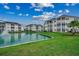 Picturesque view of white condominiums surrounding a tranquil pond with lush green lawns and vibrant landscaping at 901 West Port Dr. # 305, North Myrtle Beach, SC 29582