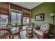 Cozy sunroom features pond views, tile floor, wicker chairs and ottoman, and a colorful wall art at 901 West Port Dr. # 305, North Myrtle Beach, SC 29582