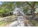 Charming stilt home featuring a screened porch, driveway, and lush surrounding trees at 910 N Dogwood Dr., Surfside Beach, SC 29575