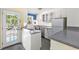 Well-lit kitchen with bright walls, white cabinets, stainless steel appliances, and access to the outside at 910 N Dogwood Dr., Surfside Beach, SC 29575