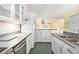 Open kitchen with white cabinetry, stainless steel dishwasher and sink plus a refrigerator at 910 N Dogwood Dr., Surfside Beach, SC 29575
