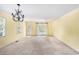 Spacious living room featuring a chandelier, large windows, and sliding glass doors to the outside at 910 N Dogwood Dr., Surfside Beach, SC 29575