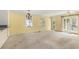 Bright living room showcasing natural light, chandelier, carpeted floors, and access to an outside entry at 910 N Dogwood Dr., Surfside Beach, SC 29575