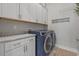 Laundry room with white cabinets and countertop, and blue washer and dryer at 945 Waterbridge Blvd., Myrtle Beach, SC 29579