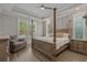Spacious main bedroom featuring a four-poster bed, tray ceiling, and many windows at 945 Waterbridge Blvd., Myrtle Beach, SC 29579