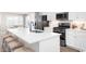 Modern kitchen features stainless steel appliances, white cabinets, and a large center island at Ryegrass Way # 0029F, Murrells Inlet, SC 29576