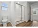 Well-lit bathroom featuring a toilet, glass-enclosed shower, and access to the bedroom at 1004 Kinness Dr., Conway, SC 29527