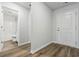 Hallway featuring wood-look flooring, leading to a bathroom and door to the left, with a door at the end at 1004 Kinness Dr., Conway, SC 29527