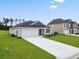 Inviting one-story home with a long driveway and landscaping leading to the attached two-car garage at 1004 Kinness Dr., Conway, SC 29527