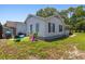 Exterior view of a home's backyard with green grass, outdoor seating, and easy access to the home at 10071 Kings Rd., Myrtle Beach, SC 29572