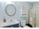 Well-lit bathroom featuring a sink, toilet, cabinet storage, and a glass-enclosed shower stall at 10071 Kings Rd., Myrtle Beach, SC 29572