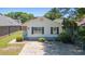 Charming home featuring a concrete driveway, small porch and black shutters in a neighborhood full of trees at 10071 Kings Rd., Myrtle Beach, SC 29572