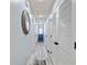 Hallway with light blue walls, wood plank ceiling, a decorative mirror, and doors to various rooms at 10071 Kings Rd., Myrtle Beach, SC 29572