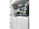 Convenient laundry area with a front-load washer, dryer, and ample storage space on shelves at 10071 Kings Rd., Myrtle Beach, SC 29572
