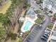 Aerial view of a community pool with a pergola, lounge chairs, tropical landscaping, and a parking area at 1009 World Tour Blvd. # 105, Myrtle Beach, SC 29579