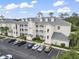 View of the condo with a manicured lawn, balconies, and ample parking space at 1009 World Tour Blvd. # 105, Myrtle Beach, SC 29579
