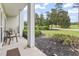 Covered porch area with seating and view of landscaped yard and golf course at 1009 World Tour Blvd. # 105, Myrtle Beach, SC 29579