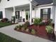 Inviting front porch with green door, rocking chairs, and lush landscaping at 101 Karlie Ln., Aynor, SC 29511