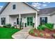 Inviting front porch with green double doors, rocking chairs, and lush landscaping at 101 Karlie Ln., Aynor, SC 29511