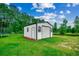 White outbuilding with a large roll-up door and lush green lawn at 101 Karlie Ln., Aynor, SC 29511