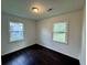 Bright bedroom with dark hardwood floors, neutral walls, and two windows at 109 S Maple Ave., Andrews, SC 29510