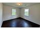 Cozy bedroom featuring dark hardwood floors, neutral walls, and two windows providing ample natural light at 109 S Maple Ave., Andrews, SC 29510
