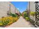 Lush garden walk featuring vibrant yellow flowers, decorative insect sculptures, and neatly trimmed greenery at 1107 Woodside Dr., Conway, SC 29526