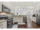 Well-lit kitchen features stainless steel appliances, granite countertops, white cabinetry, and hardwood floors at 1188 Peterson St., Myrtle Beach, SC 29577