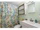 Bright bathroom featuring a pedestal sink, a decorative shower curtain and a wall cabinet for storage at 1217 S Ocean Blvd. # 5, Surfside Beach, SC 29575