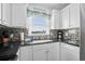 Modern kitchen showcasing white cabinets, granite countertops and stylish backsplash at 1217 S Ocean Blvd. # 5, Surfside Beach, SC 29575