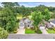 Stunning aerial view of a home nestled in a lush, wooded community with a golf course and lake nearby at 124 Turtle Creek Dr., Pawleys Island, SC 29585