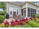 Cozy patio with wicker furniture, a grill, and vibrant flowers, perfect for outdoor entertaining and relaxation at 124 Turtle Creek Dr., Pawleys Island, SC 29585